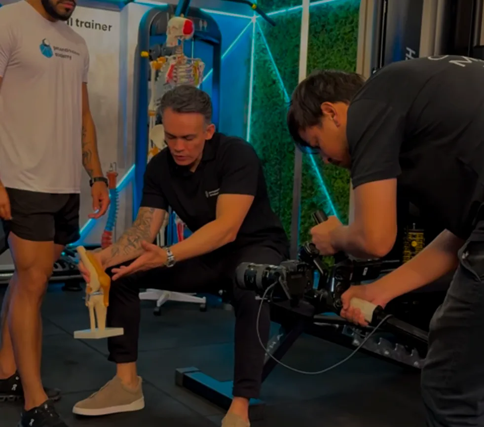 Bastidores da gravação da pós em Biomecânica: André Albuquerque demonstrando com modelo anatômico enquanto a câmera captura a aula